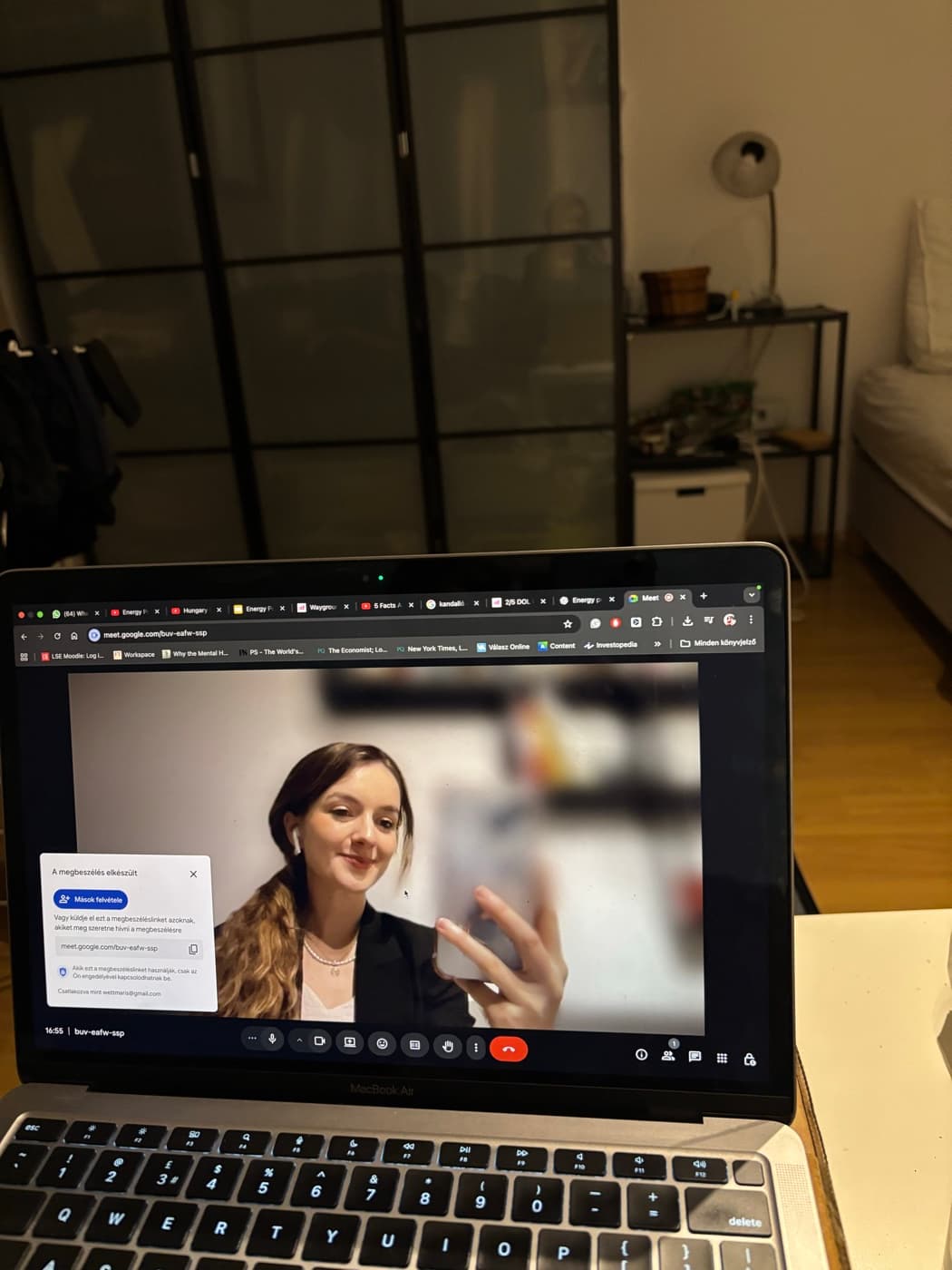 A laptop on a desk late at night, mid video call