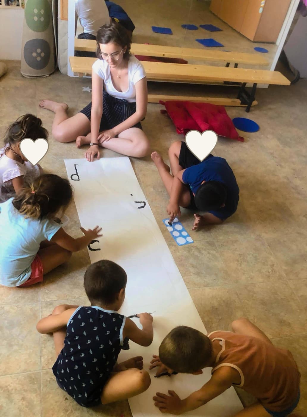 Children painting with faces covered for privacy